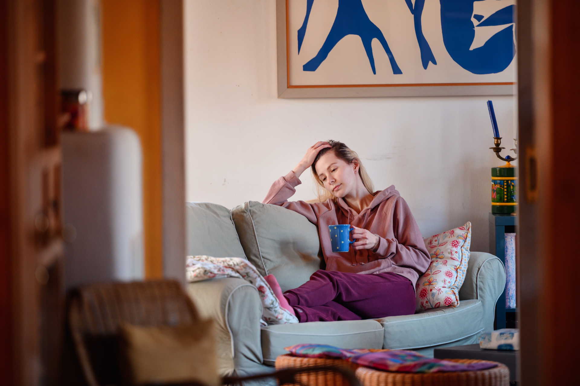Frau sitzt abends nachdenklich auf dem Sofa und denkt über Verantwortung im Alltag nach
