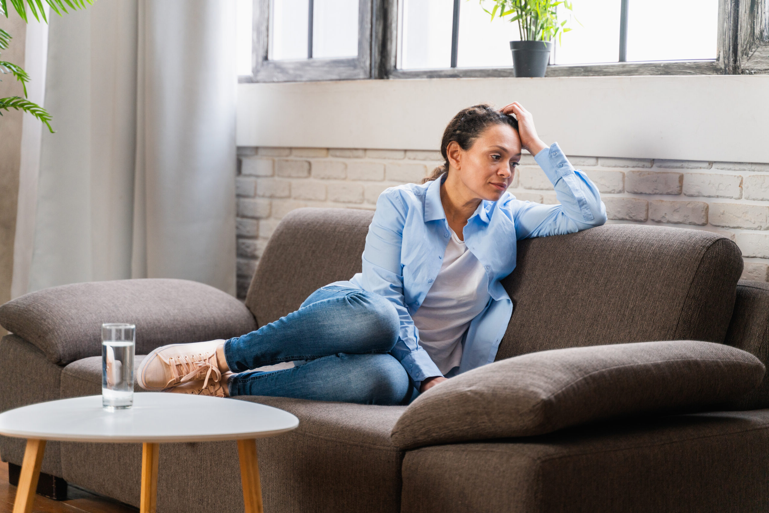 Mental-Light | Frau sitzt erschöpft auf dem Sofa